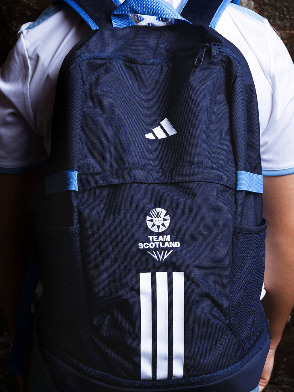 Man wearing navy adidas Team Scotland backpack.