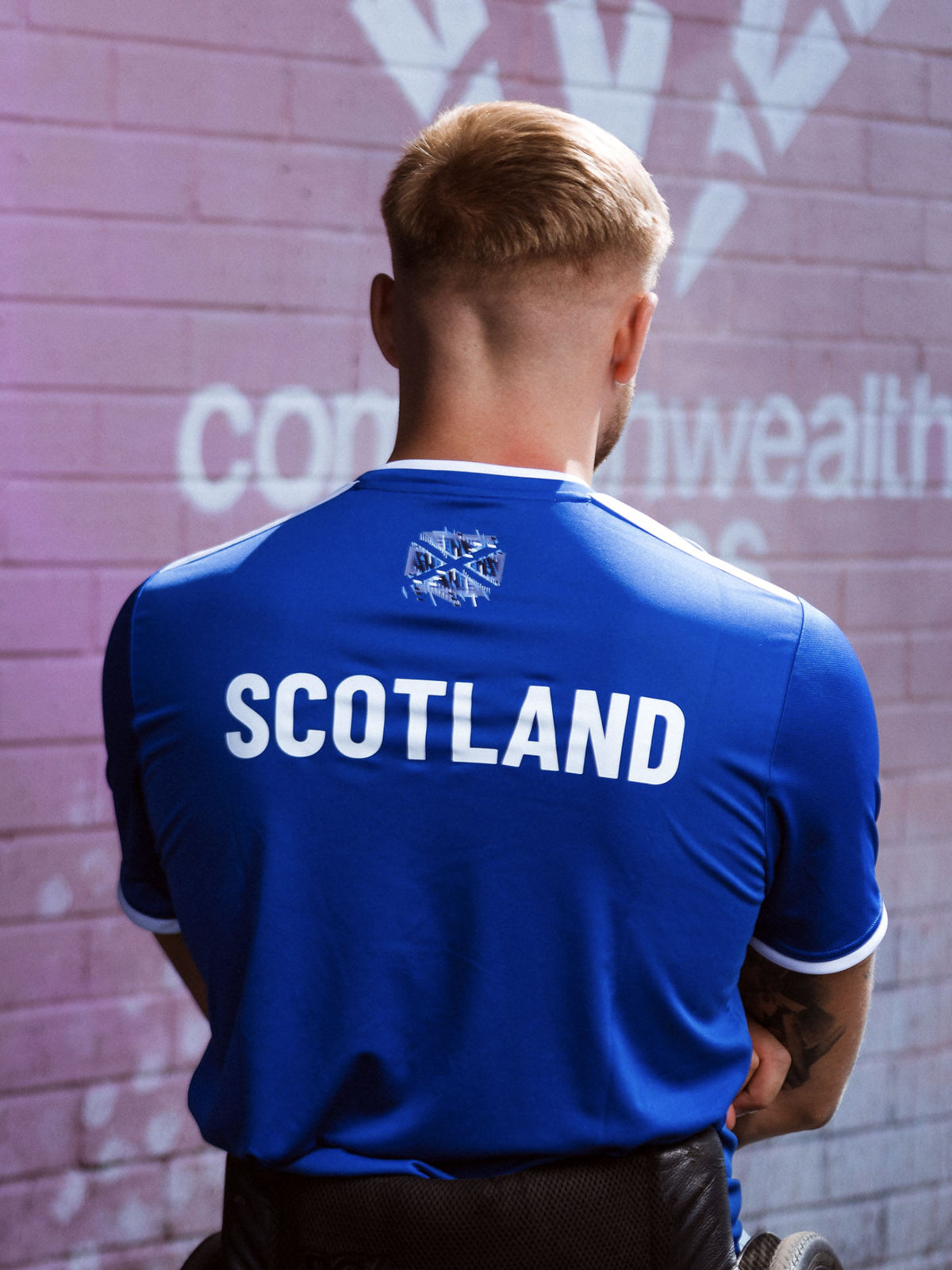 Back view of man wearing royal blue adidas Team Scotland jersey.