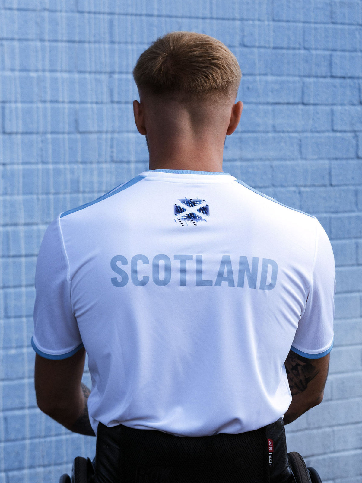 Back view of man wearing white adidas Team Scotland jersey.